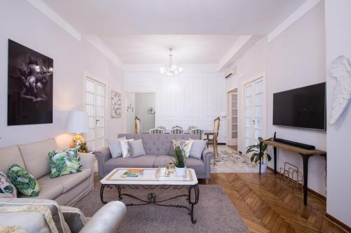 een woonkamer met een bank en een tafel bij Grandi Residenze Napoli- Piazza Carità con vista in Napels