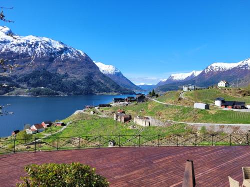 a village on a hill with a lake and mountains at Flohytta in Stryn