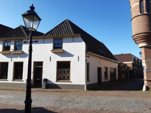 a street light in front of a white building at De Kapelle in Oudewater in Oudewater