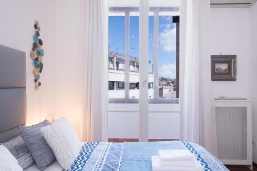een slaapkamer met een bed en een groot raam bij Carità Grandi Residenze Napoli in Napels