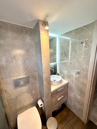a bathroom with a sink and a toilet and a shower at Tinos Boutique House in Tinos