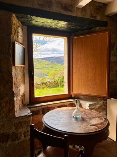 a table in a room with a window at Cabaña Pasiega Lo Macario in Resconorio