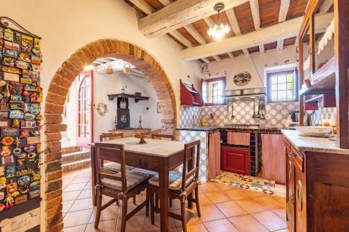 a kitchen with an archway and a table and chairs at Podere Poggiolo in Trequanda