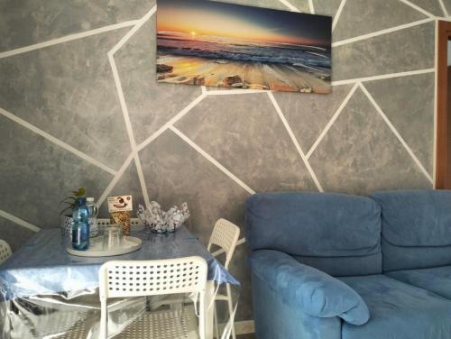 a living room with a blue couch and a table at Casa MaryGiò in San Pietro in Bevagna
