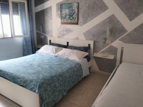 a bedroom with a bed with a blue comforter at Casa MaryGiò in San Pietro in Bevagna