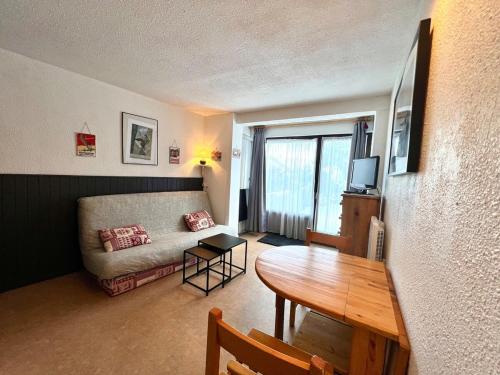 un salon avec une table et un canapé dans l'établissement Au pied des pistes studio et jardin au soleil, à Montgenèvre