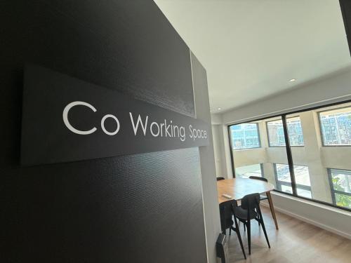 a company sign on a wall in a room with a table at P168 Hostel Samui in Chaweng