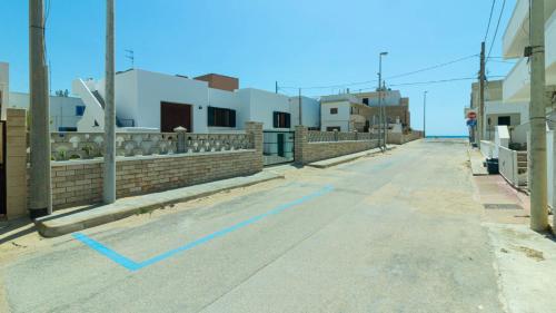 una strada vuota con una linea blu sulla strada di Villa Casa Vacanza Sea Front a Torre Pali