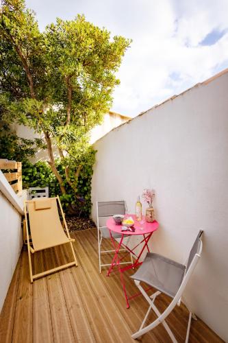 a small patio with a pink table and chairs at Le Fangassier in Saintes-Maries-de-la-Mer