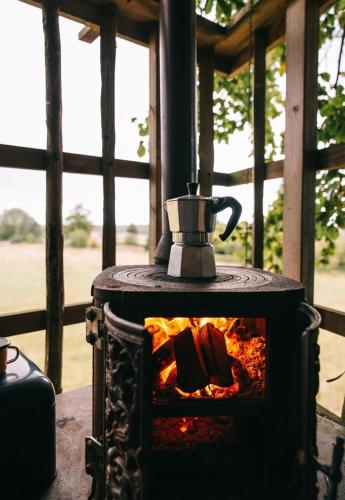 a tea kettle sitting on top of a fireplace at Treehouse escape in Kværndrup