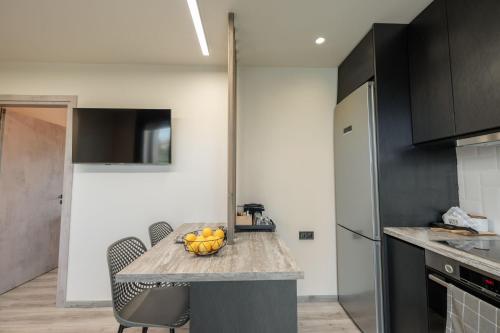 a kitchen with a table with a bowl of fruit on it at Grand Kourouta Pool Apartments in Kourouta