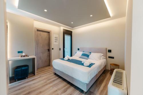 a bedroom with a large bed with blue and white pillows at Grand Kourouta Pool Apartments in Kourouta