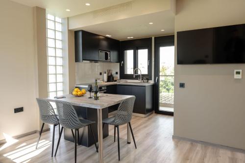 a kitchen with a table and chairs in a kitchen at Grand Kourouta Pool Apartments in Kourouta
