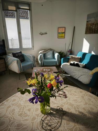 un salon avec un vase de fleurs sur une table dans l'établissement Escale Détente à Fouras, à Fouras