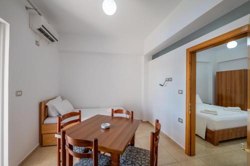 a dining room with a table and a bedroom at Aleksander ApartHotel in Ksamil