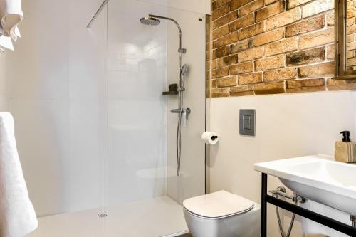 a bathroom with a shower and a toilet and a sink at TatryTop Domy Manowce z jacuzzi in Kościelisko