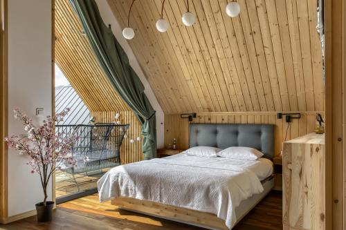 a bedroom with a bed with a wooden ceiling at TatryTop Domy Manowce z jacuzzi in Kościelisko