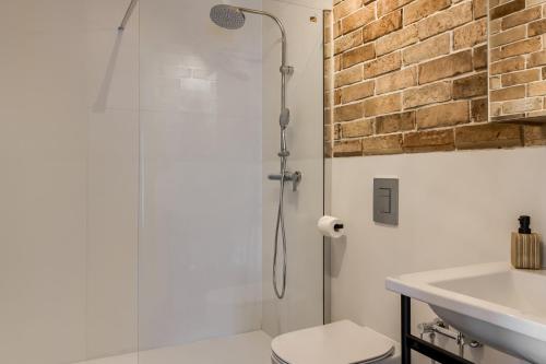 a bathroom with a shower and a toilet and a sink at TatryTop Domy Manowce z jacuzzi in Kościelisko