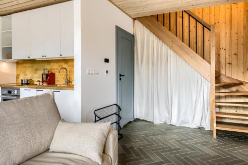 a living room with a couch and a staircase at TatryTop Domy Manowce z jacuzzi in Kościelisko