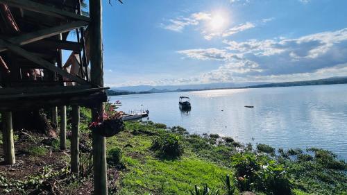 a boat on a lake with a house at Elsamere Lodge Naivasha in Naivasha