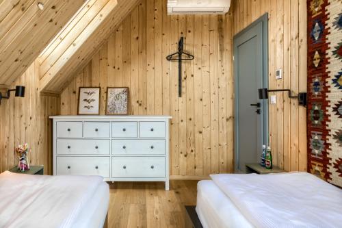 a bedroom with two beds and a dresser at TatryTop Domy Manowce z jacuzzi in Kościelisko