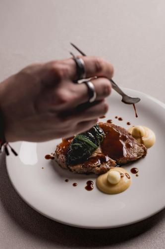 a person holding a fork and a plate of food at Hotel Garden Experience in Città di Castello