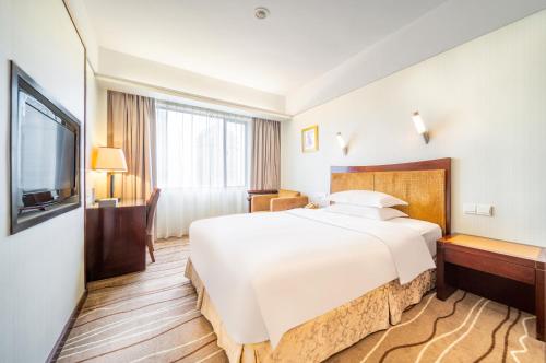 Ένα ή περισσότερα κρεβάτια σε δωμάτιο στο Zhongshan International Hotel