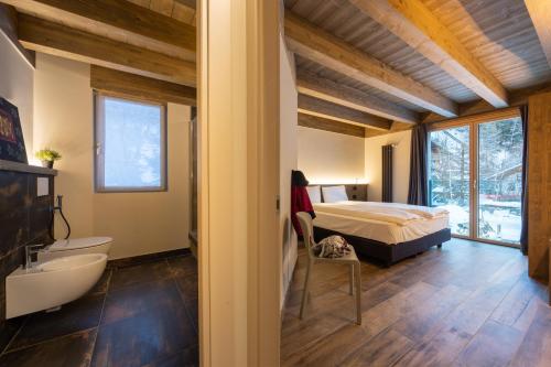 a bedroom with a bed and a bathroom with a tub at Lillaz Home - Apartments in Cogne