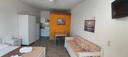 a room with a bed and a couch and a kitchen at Amaranthos Skiathos View in Megali Ammos