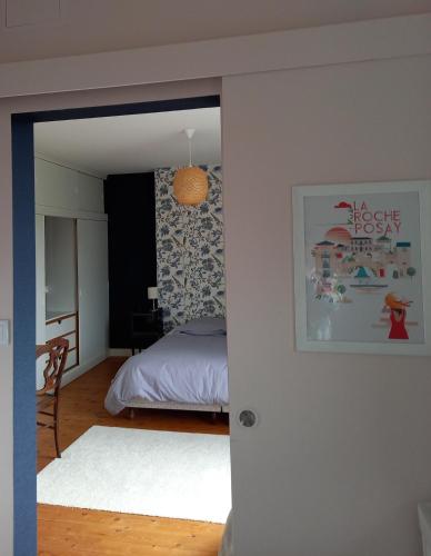 a bedroom with a bed and a table and a mirror at La Marjolaine in La Roche-Posay