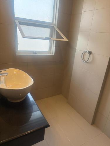 a bathroom with a sink and a shower with a window at Mediterranean Apartments in Islamabad