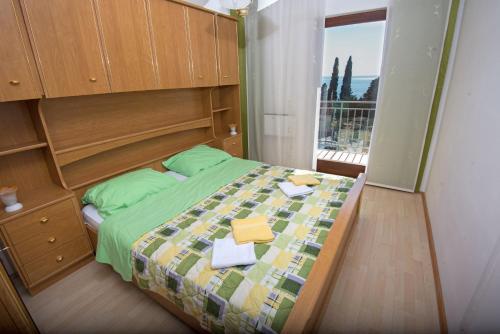 a bedroom with a bed and a large window at Zara apartma in Podstrana