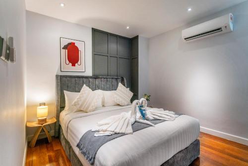 ein Schlafzimmer mit einem großen Bett mit weißer Bettwäsche in der Unterkunft Novo Ampang, Luxury Premium 3BR Penthouse, Kuala Lumpur by Cobnb in Kuala Lumpur