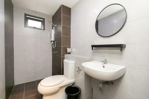 a bathroom with a toilet and a sink and a mirror at Meritus Residensi Seaview Pent Hauz 3BR 10Pax in Perai