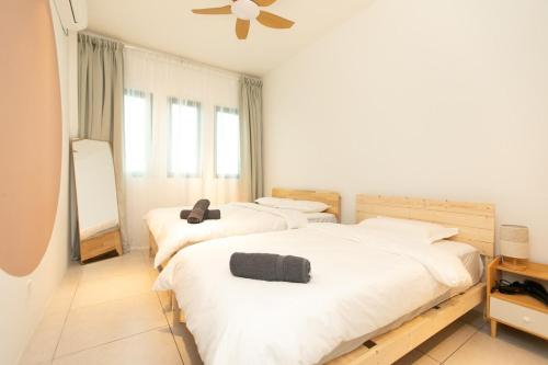 a bedroom with two beds and a ceiling fan at Meritus Residensi Seaview Pent Hauz 3BR 10Pax in Perai