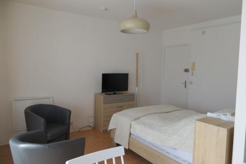 une chambre avec un lit, une chaise et une télévision dans l'établissement Chez Amélie Studio 2 Etoiles 50m des Thermes, à Amélie-les-Bains-Palalda