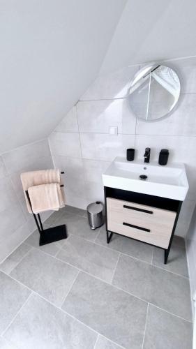 a bathroom with a sink and a mirror and a chair at Moderne Apartments mit Klima, perfekter Anbindung ins Zentrum und kostenlose Parkplätze! in Vienna