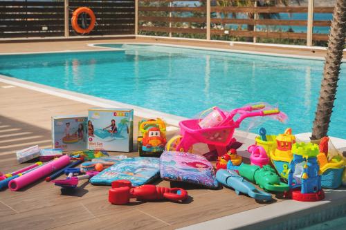 a pile of toys sitting next to a swimming pool at Seaview Garden Villa - Heated Pool & Sauna in Stalos