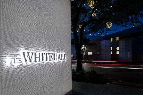 a white building with a sign that reads the whitehall at The Whitehall Houston in Houston
