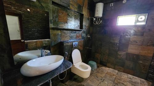 a bathroom with a sink and a toilet and a tub at Hong Sau Resort in Sakleshpur