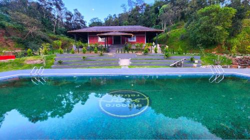 a house with a pool of water in front of it at Hong Sau Resort in Sakleshpur
