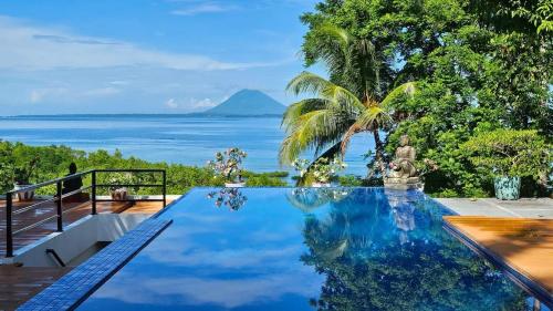 a swimming pool with a view of the ocean at Nayara Villa Desa Budo in Wori