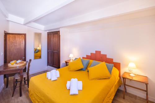 a bedroom with a large yellow bed with yellow pillows at Le Fangassier in Saintes-Maries-de-la-Mer