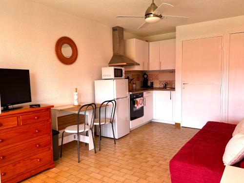 Il comprend une cuisine avec un bureau et un réfrigérateur. dans l'établissement Studio le grau du roi, 4 personnes, place de parking, au Grau-du-Roi