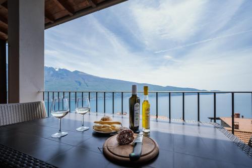 a table with two glasses of wine and some food at Residence Erika in Tignale
