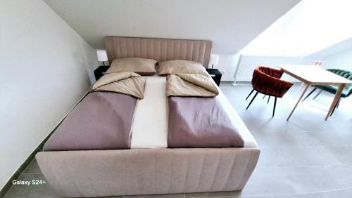 a bed in a room with a table and chairs at Moderne Apartments mit Klima, perfekter Anbindung ins Zentrum und kostenlose Parkplätze! in Vienna