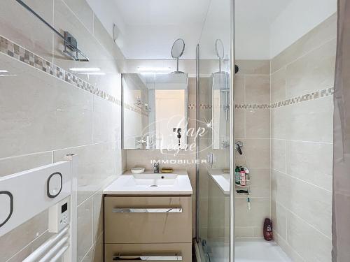 a white bathroom with a sink and a shower at Appartement T2 rénové vue mer pour 4 personnes a 50m de la plage de Pramousquier in Rayol-Canadel-sur-Mer