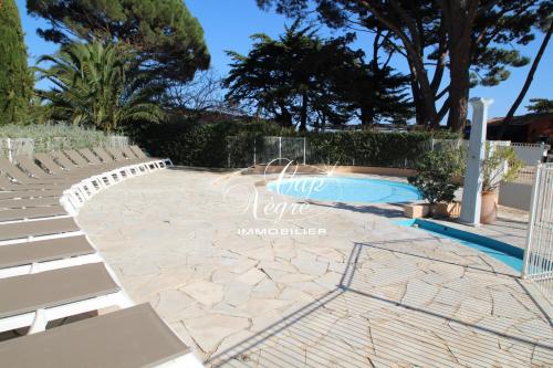 - une piscine avec des chaises à côté de la piscine dans l'établissement Appartement T2 rénové vue mer pour 4 personnes a 50m de la plage de Pramousquier, à Rayol-Canadel-sur-Mer