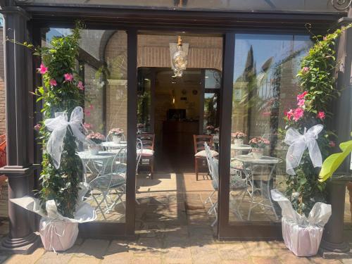 a restaurant with tables and chairs and flowers at EURO HOUSE INN airport in Fiumicino
