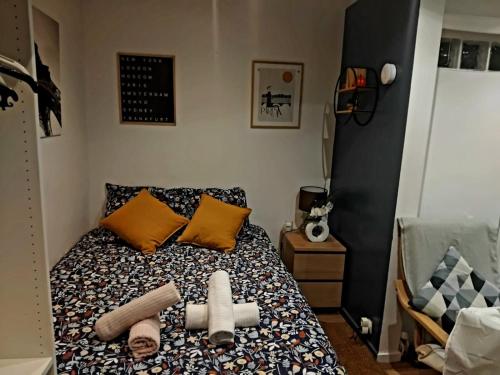 una camera da letto con un letto con cuscini di Petit studio proche de la defense a Puteaux